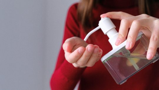 woman applying hand sanitizer
